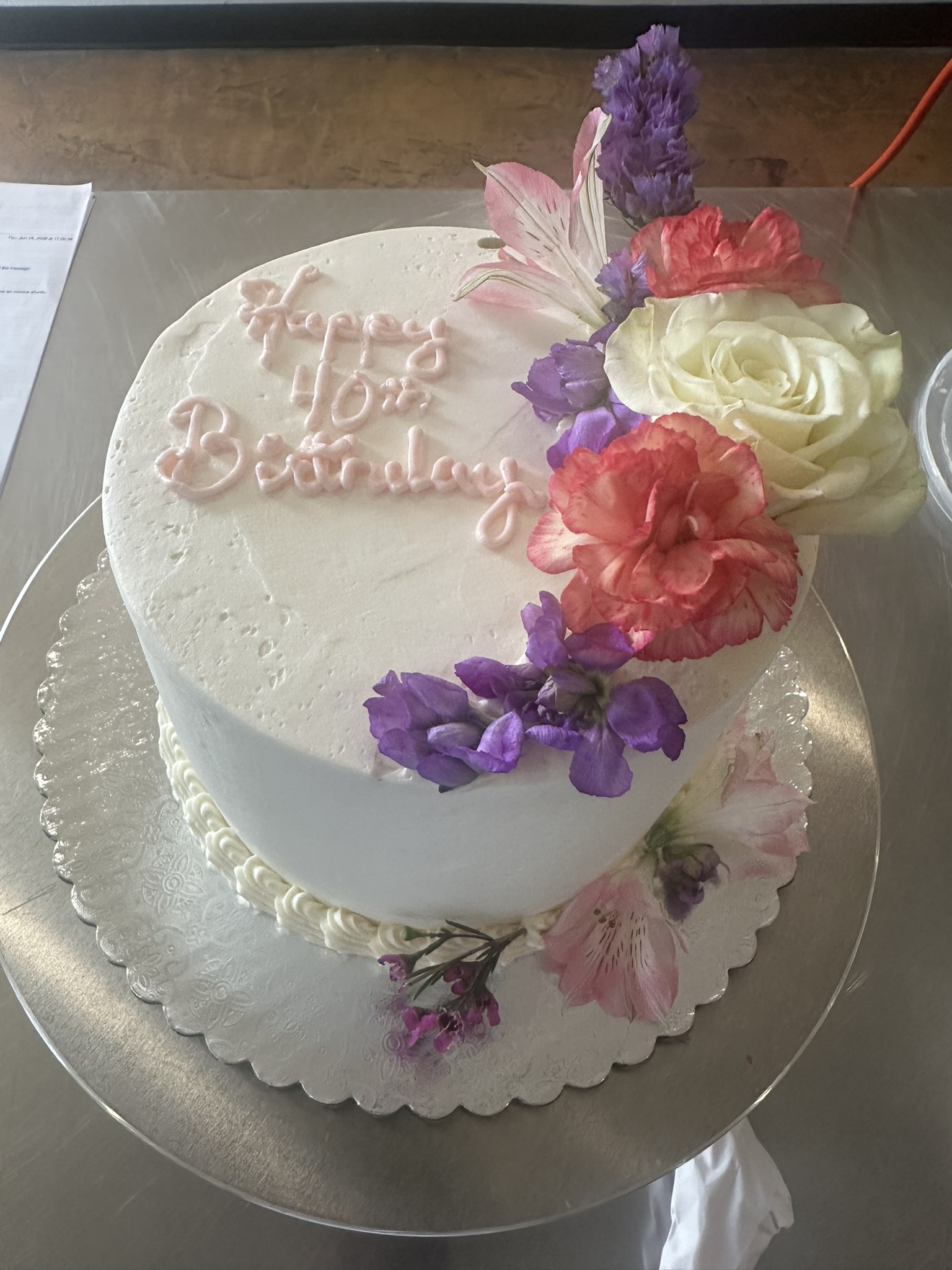 Buttercream birthday cake with colorful floral arrangement